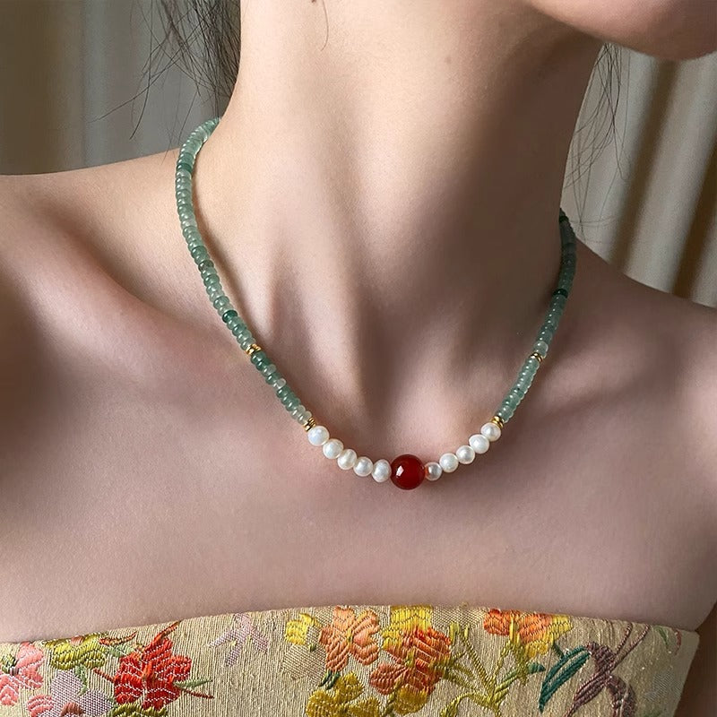Pearl, aventurine and red agate necklace worn at the collarbone